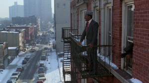 Eddie Murphy standing on a fire escape.